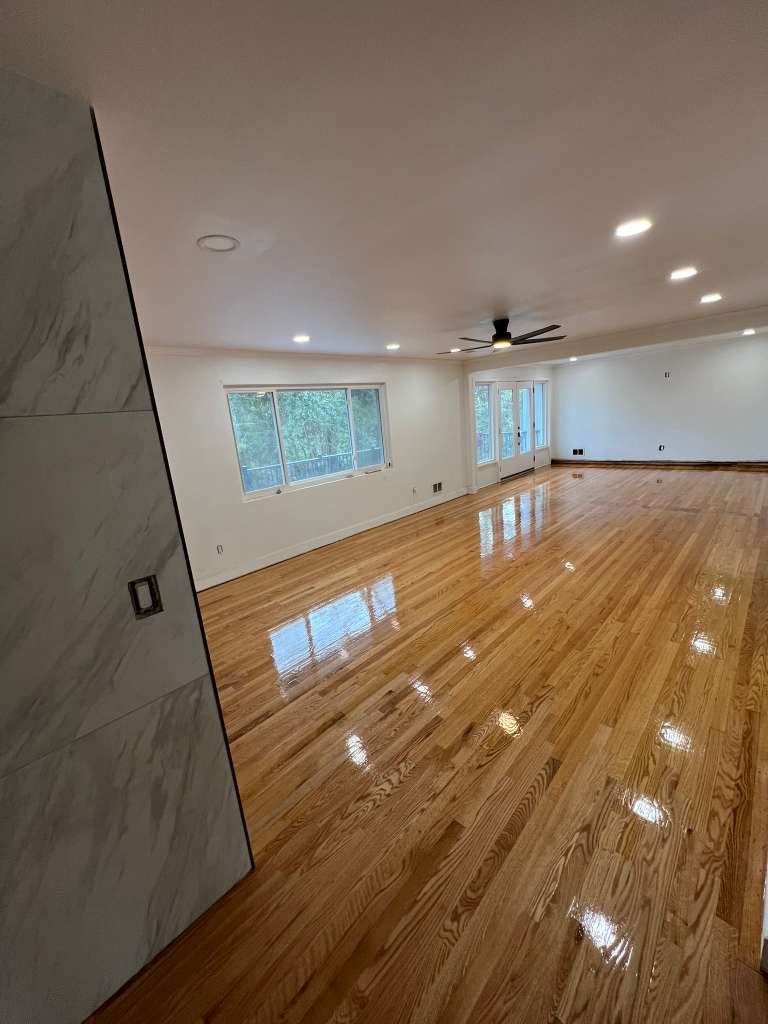 Open plan hardwood floor with marble wall accent